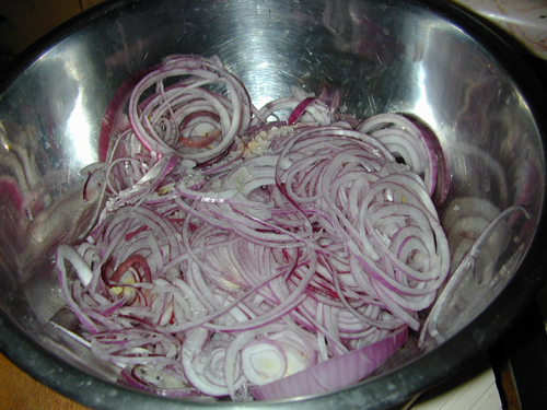 Sliced red onions with salt in a bowl
