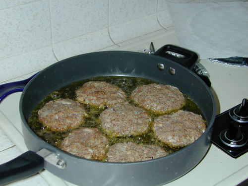 Crab cakes frying in a pan