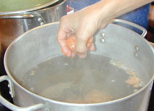 Dropping the gefilte fish balls into simmering water