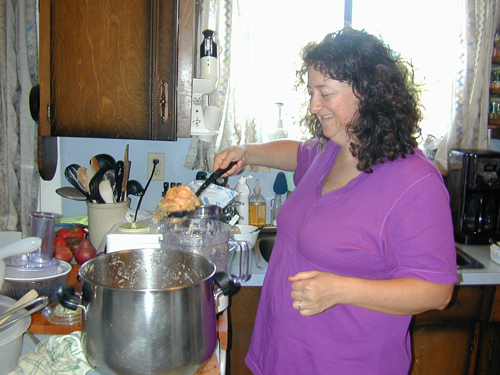 Cyndi putting the cooked apples into the food processor