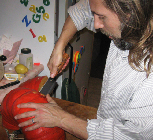 Michael cuts a pumpkin in half