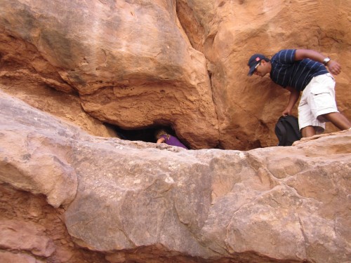 Miriam goes through a tiny arch during the Fiery Furnace Tour at Arches National Park, Utah